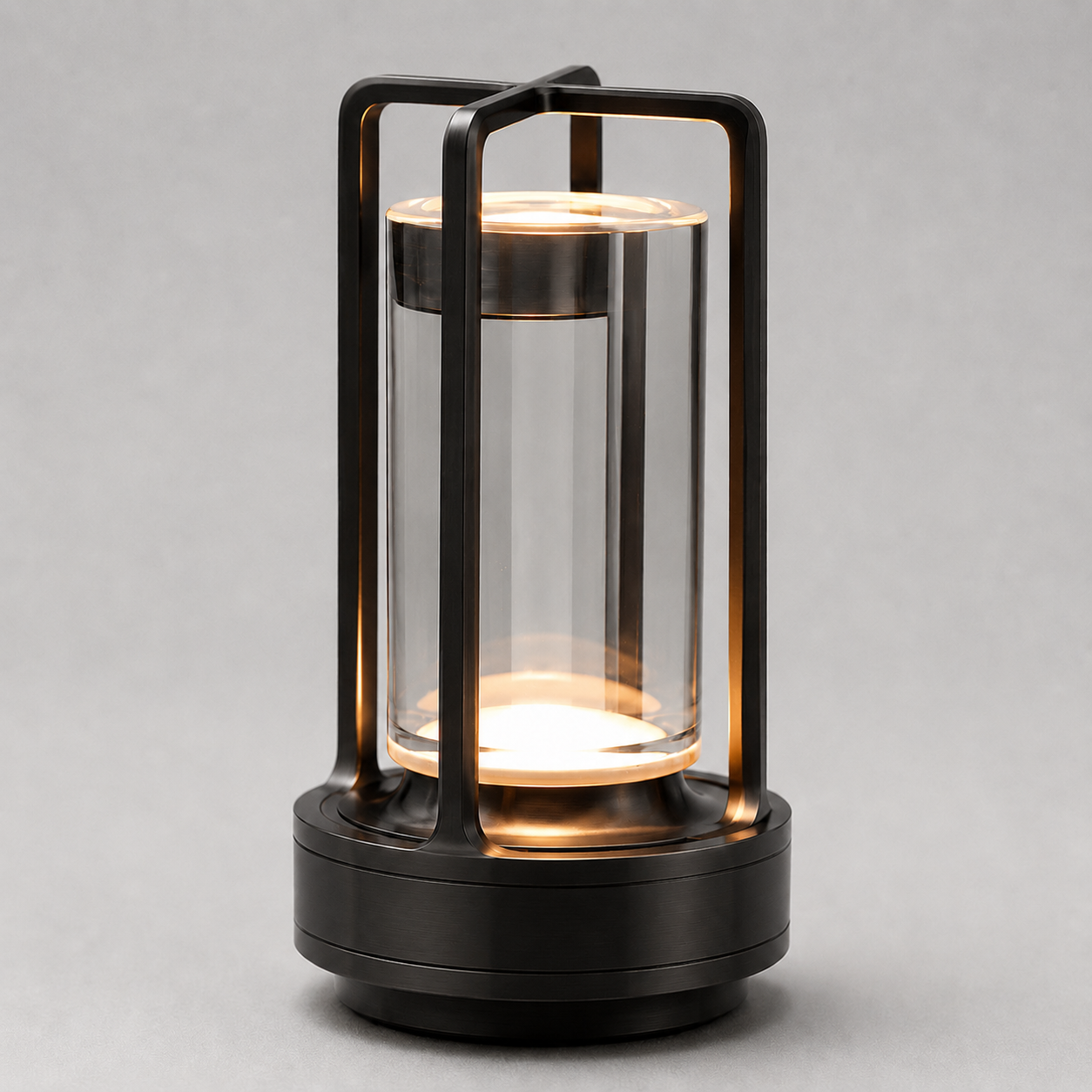 Black cordless lantern table lamp with a clear cylindrical shade, illuminated against a neutral background.