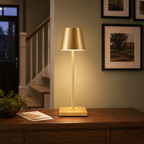 Gold table lamp glowing on a dark wood console beneath framed wall art near a staircase.