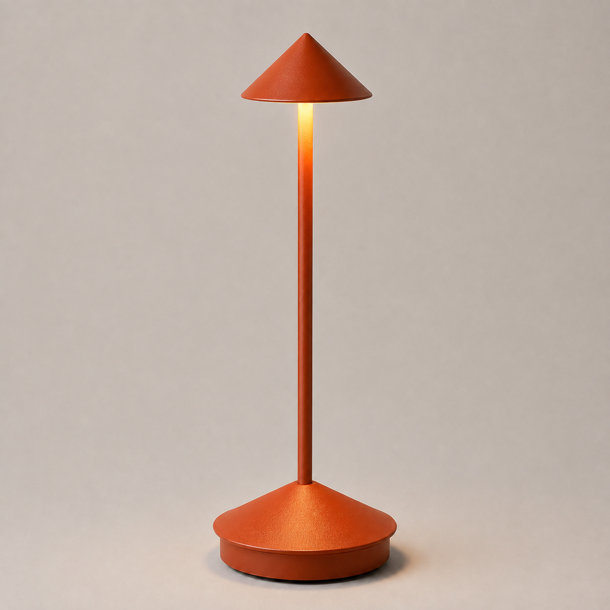 Orange cordless table lamp with a conical shade, illuminated against a neutral background.