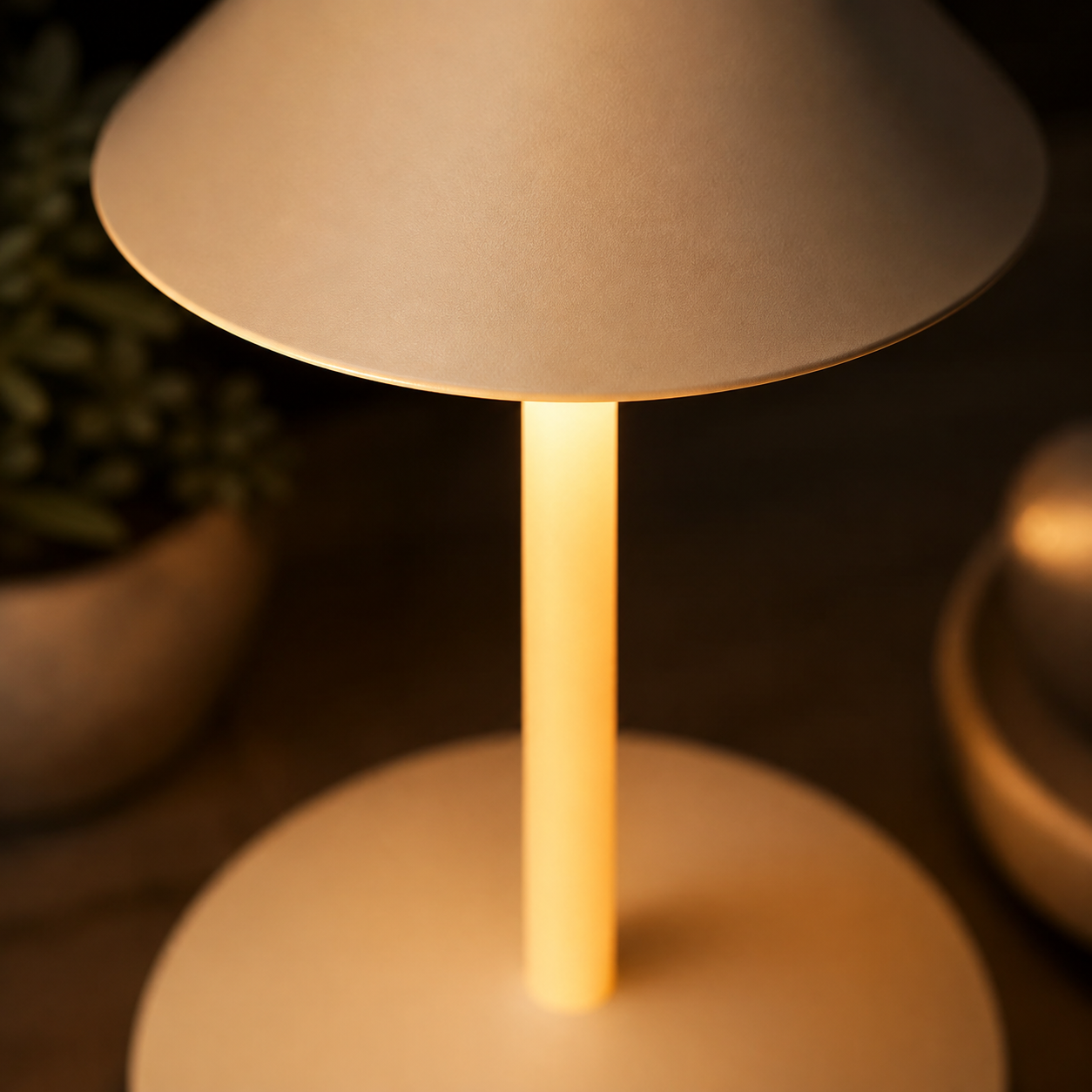 Close-up of the white conical shade, illuminated stem, and rounded lamp base.