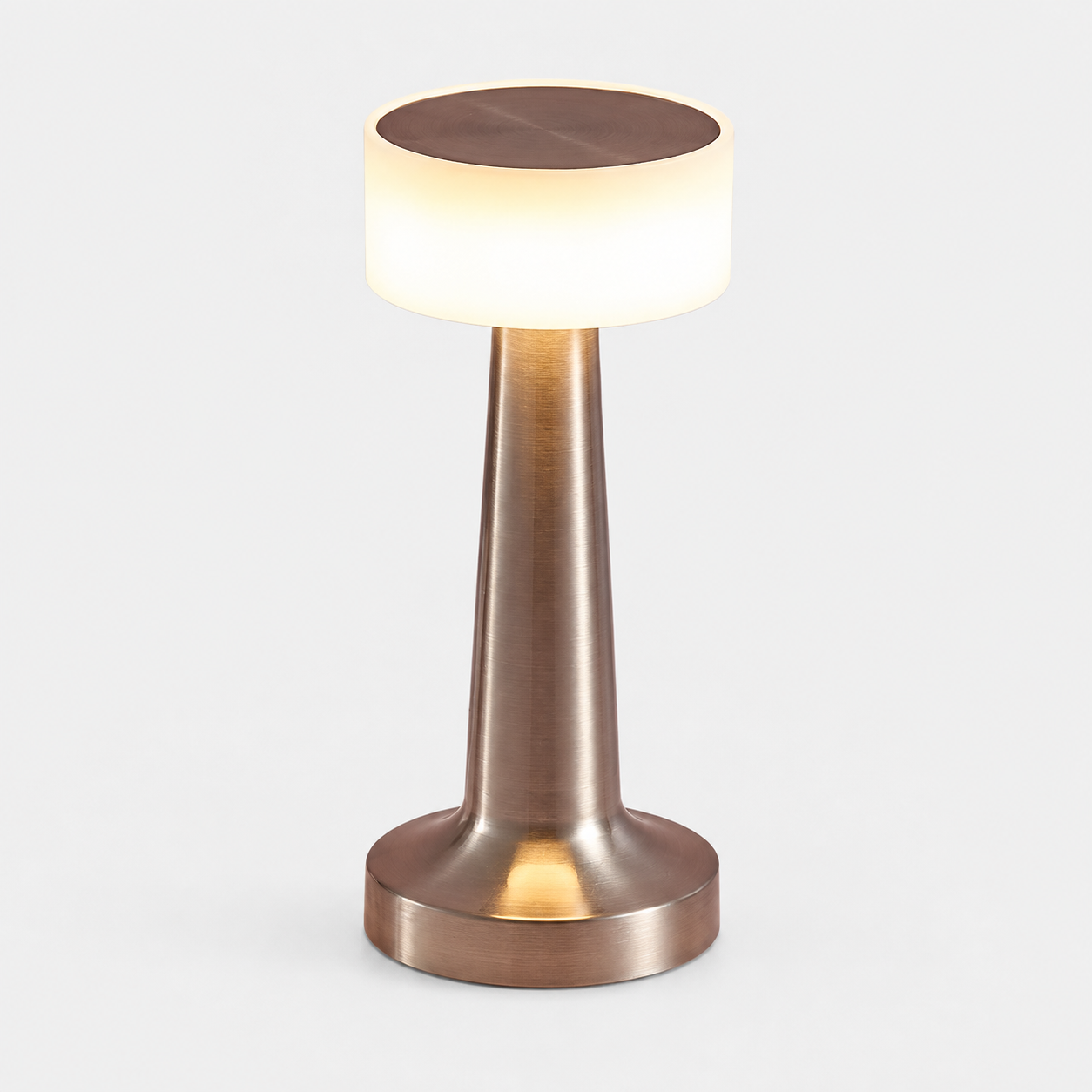Silver-tone table lamp with a glowing white shade on a plain light background.