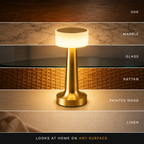 Table lamp shown against oak, marble, glass, rattan, painted wood, and linen surfaces.