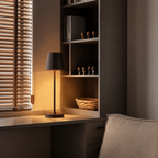 black rechargeable table lamp in a dark window-seat nook