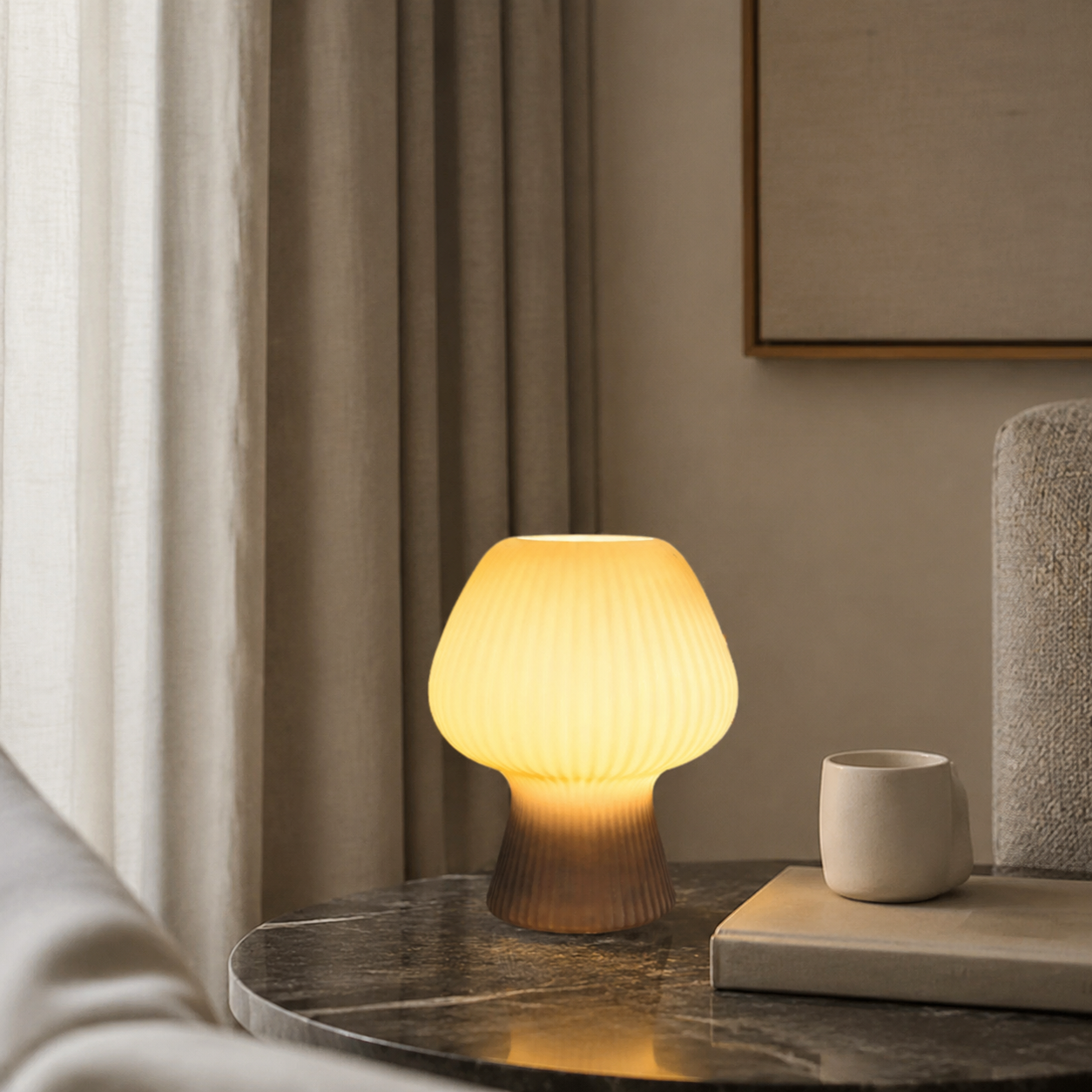 Smoke gray ribbed glass mushroom table lamp beside books.