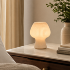 White ribbed glass mushroom table lamp displayed on a console.