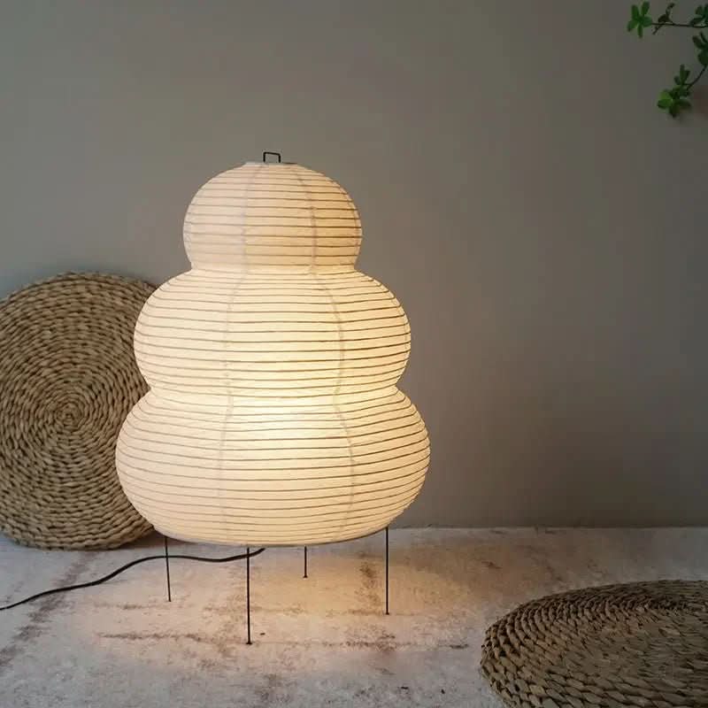 Table lamp with a stacked white rice paper shade displayed in a neutral room.