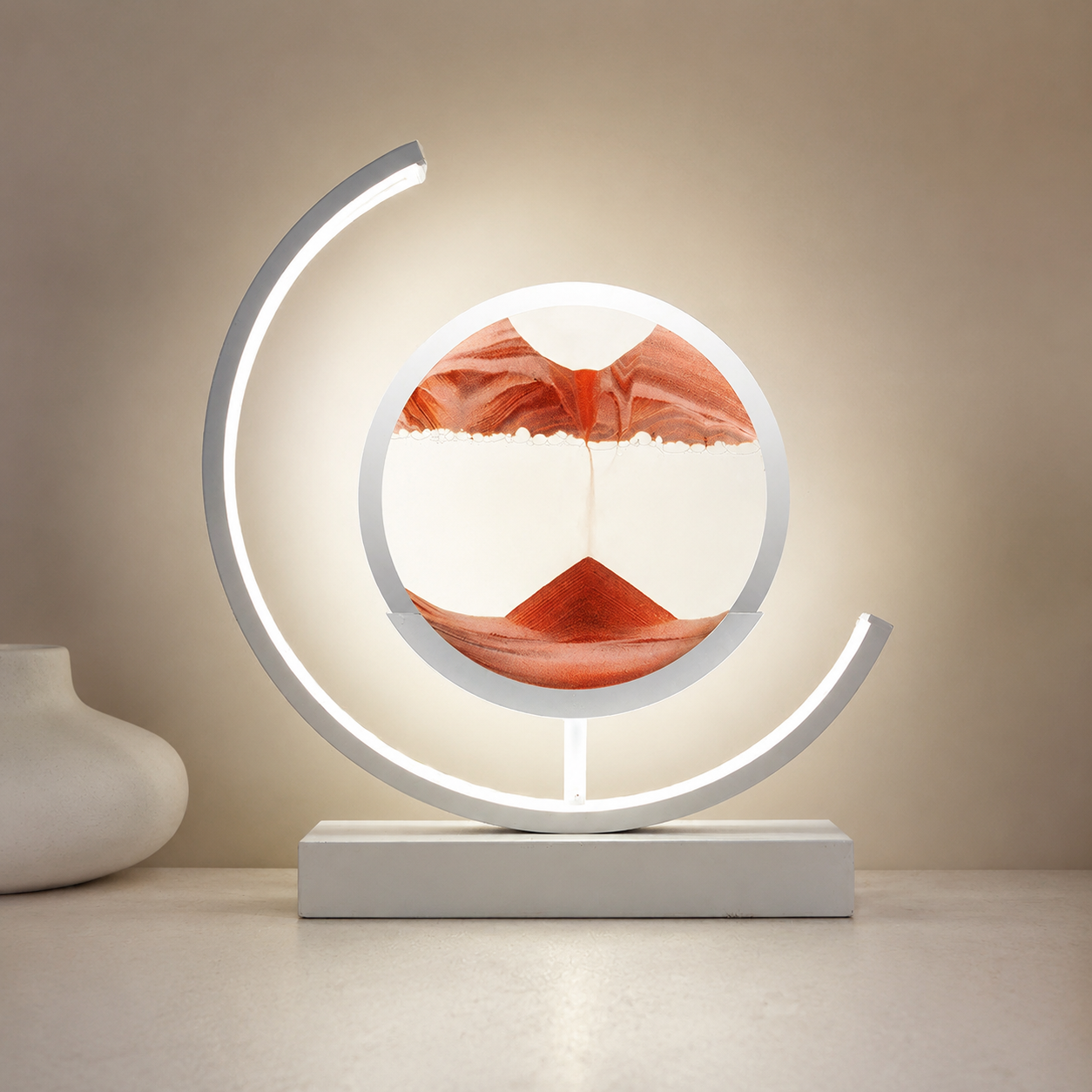 Red quicksand table lamp with a white frame glowing against a muted clay wall.