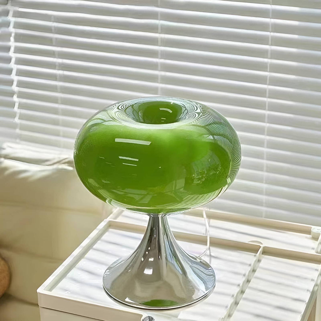 Green donut table lamp on a window-side white trolley.
