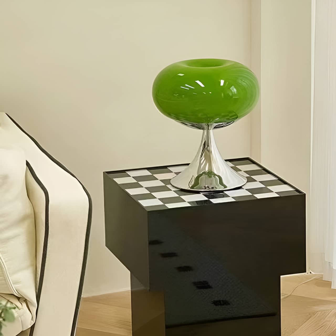 Green donut table lamp on a black cabinet with a checkerboard top.
