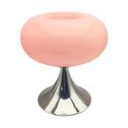 Pink donut table lamp with a rounded glass shade and metal pedestal.