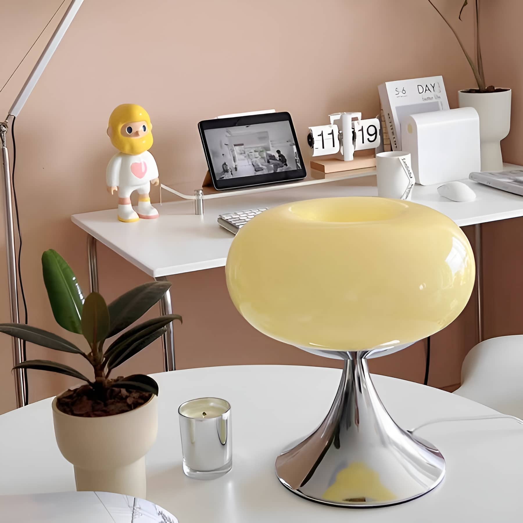 Beige donut table lamp on a desk with small decorative objects.