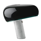 Black table lamp with a rounded shade and angled white marble base.