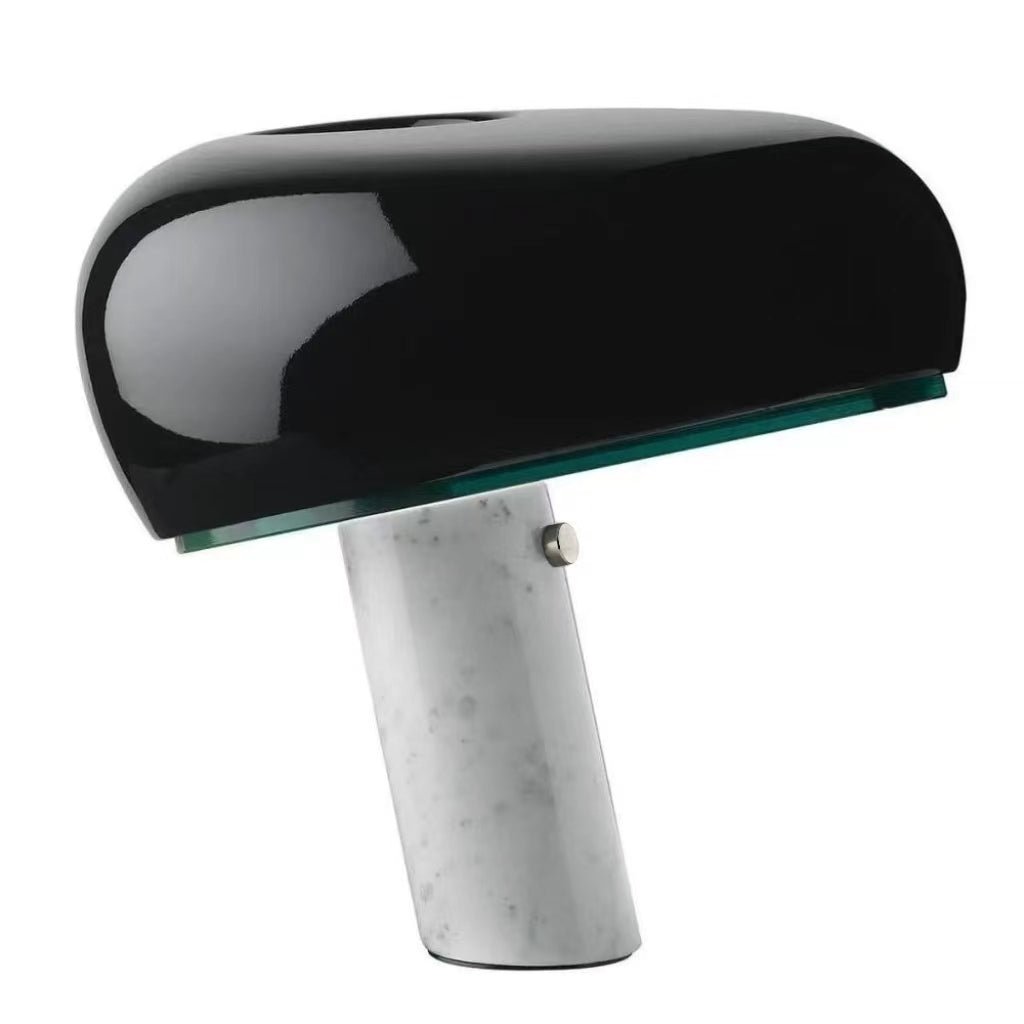 Black table lamp with a rounded shade and angled white marble base.