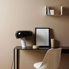 Black marble table lamp on a desk in a neutral interior.