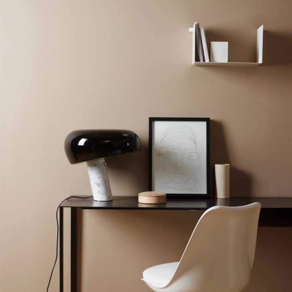Black marble table lamp on a desk in a neutral interior.