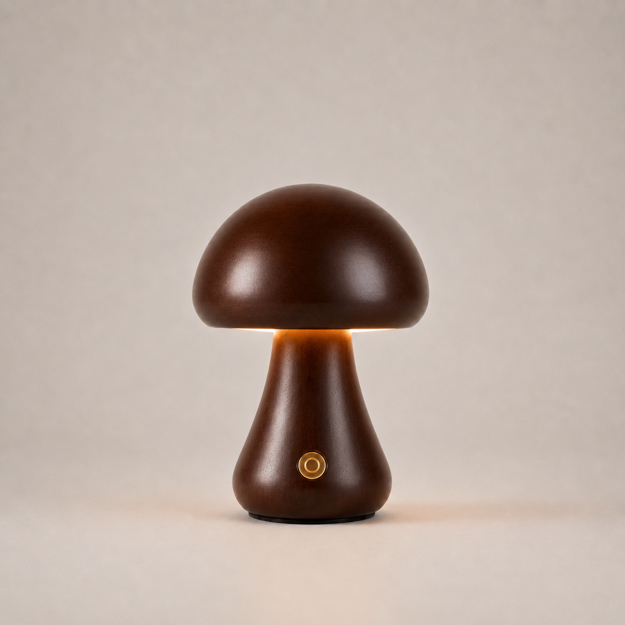 Dark brown mushroom table lamp with a short flared base, gold button, and warm light on a beige background.