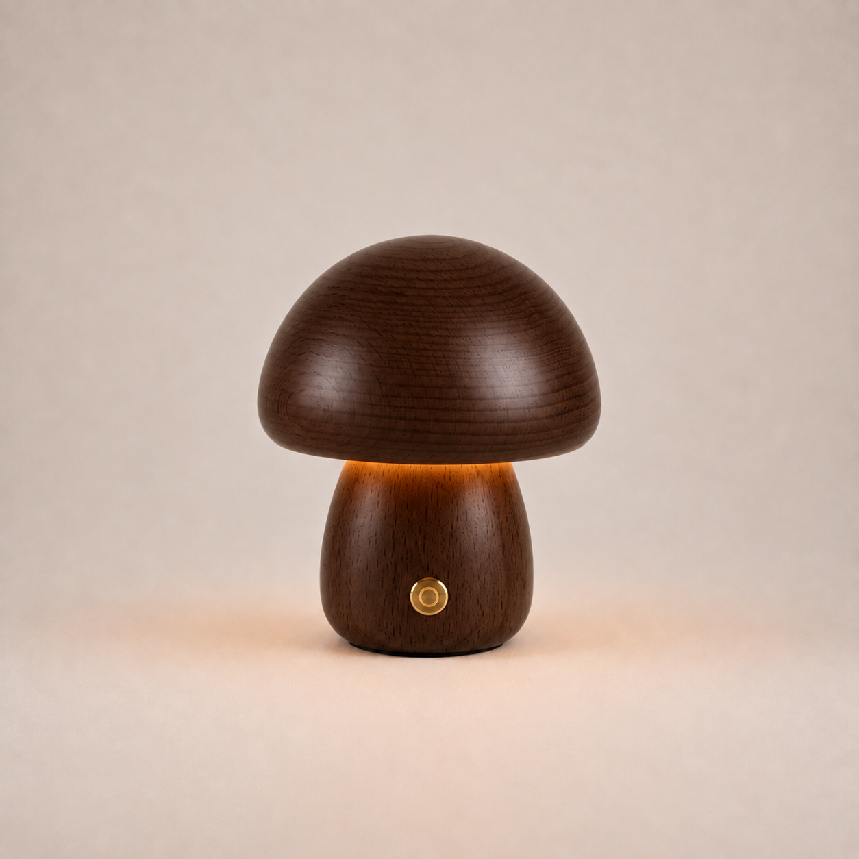 Dark brown mushroom table lamp with a short rounded base, gold button, and warm glow on a beige background.