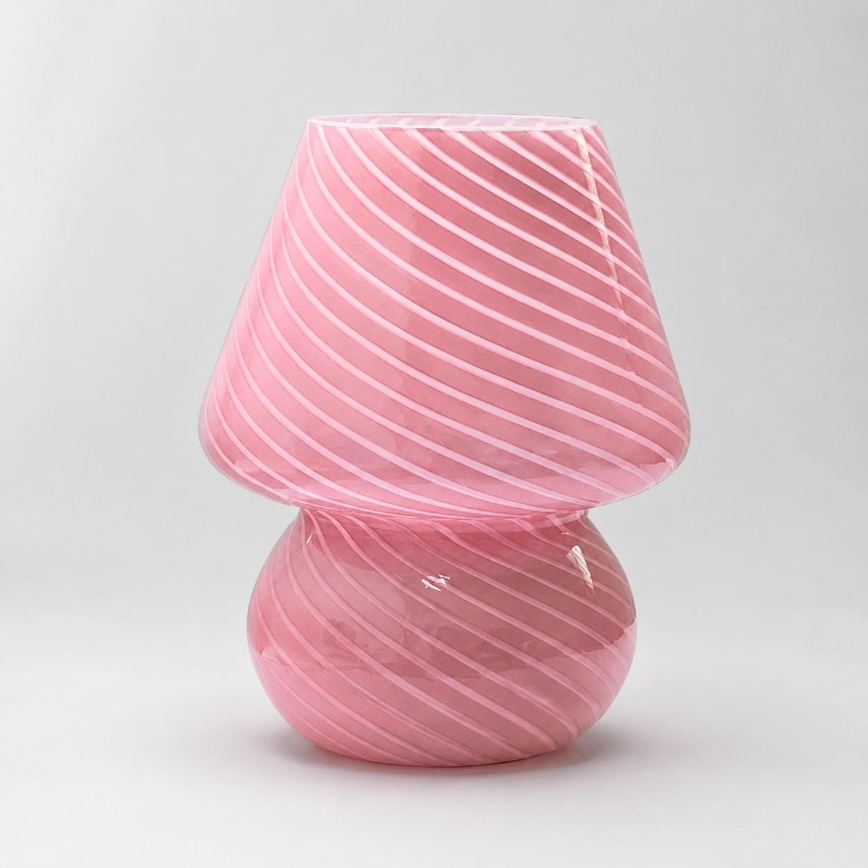 Pink swirled glass table lamp shown unlit on a light gray background.