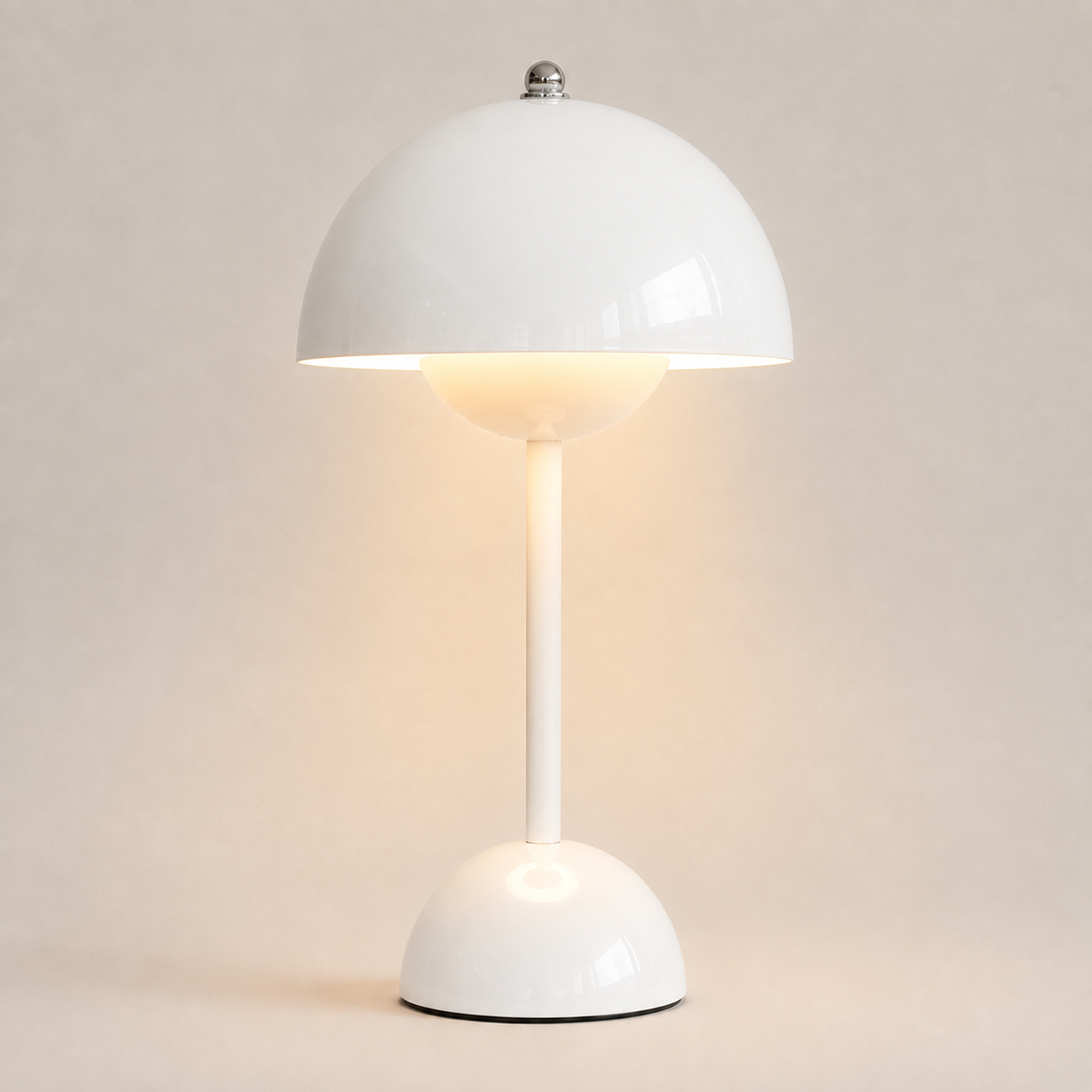 White table lamp with a rounded dome shade, slim stem, circular base, and warm downward glow.
