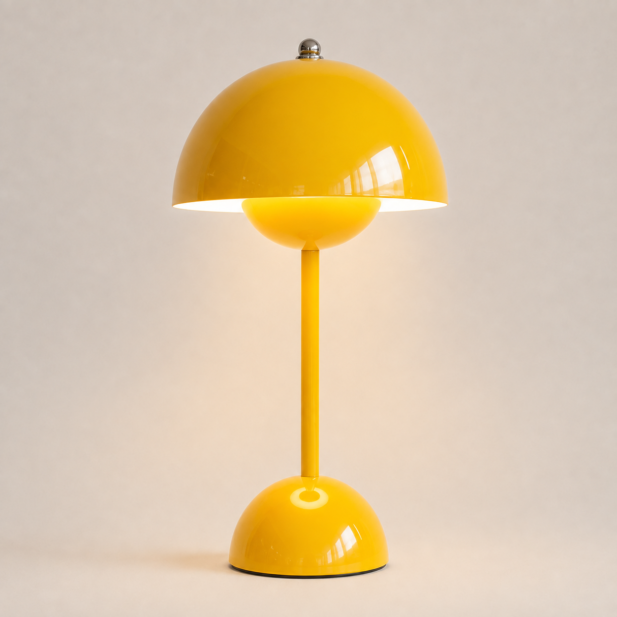 Yellow table lamp with a rounded dome shade, slim stem, circular base, and warm downward glow.