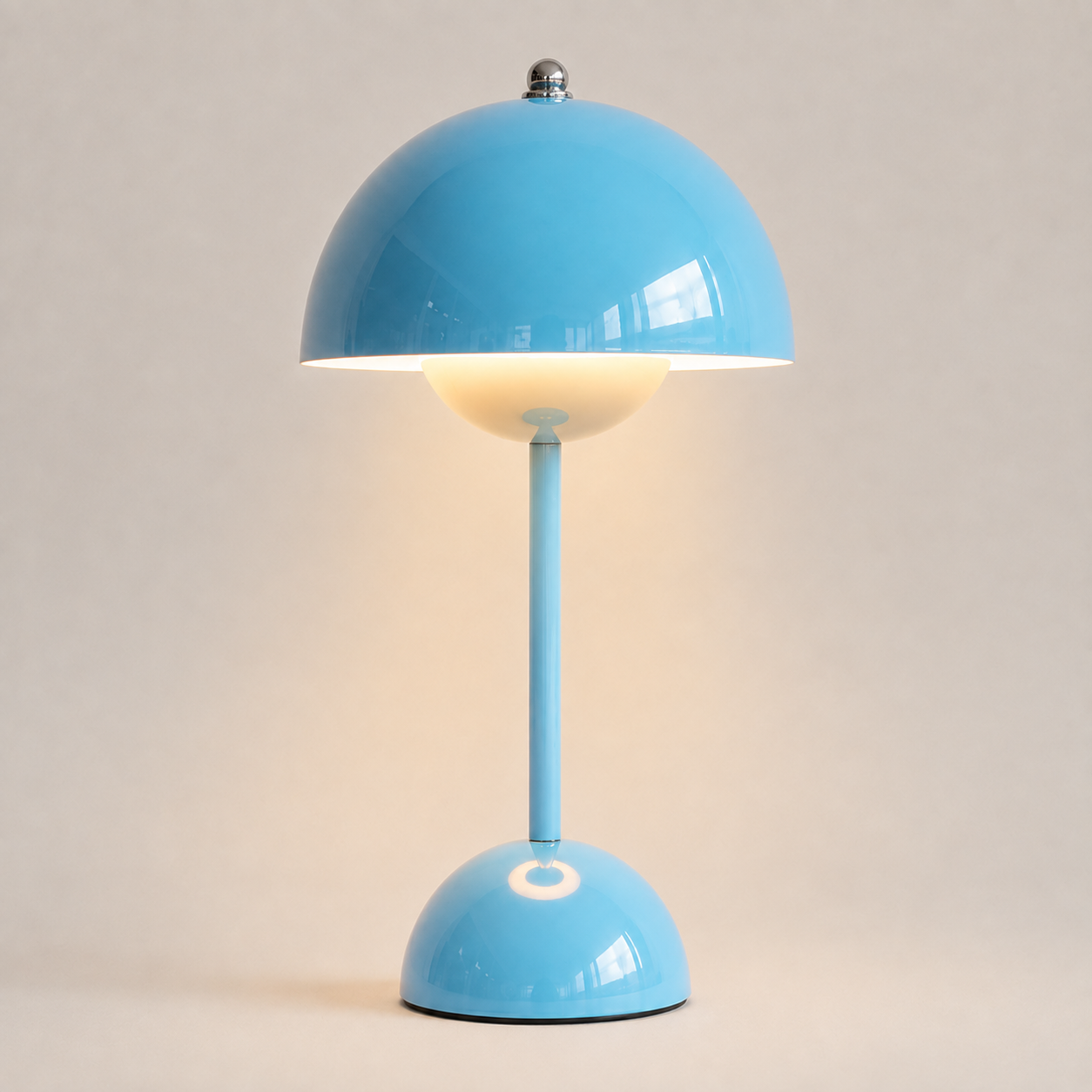 Blue table lamp with a rounded dome shade, slim stem, circular base, and warm downward glow.