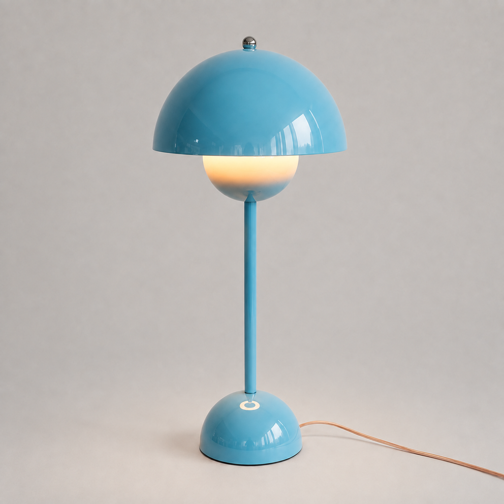 Blue table lamp with a rounded dome shade, slim stem, circular base, power cord, and warm downward glow.