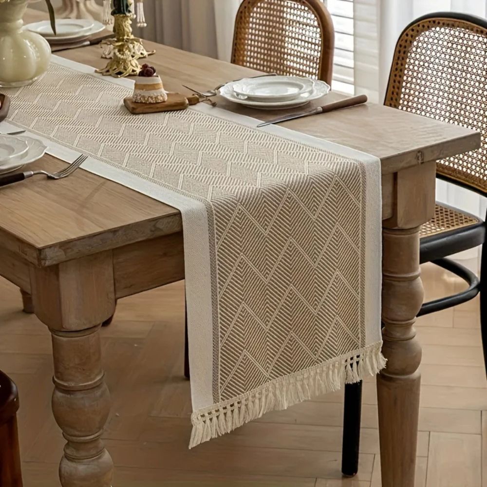 Beige table runner draped across the corner of a wooden dining table.
