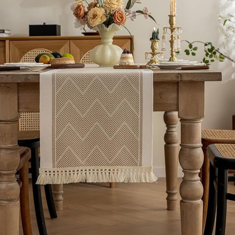 Beige table runner hanging over the end of a wooden dining table.