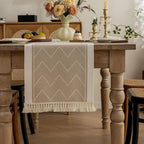 Beige table runner hanging over the end of a wooden dining table.