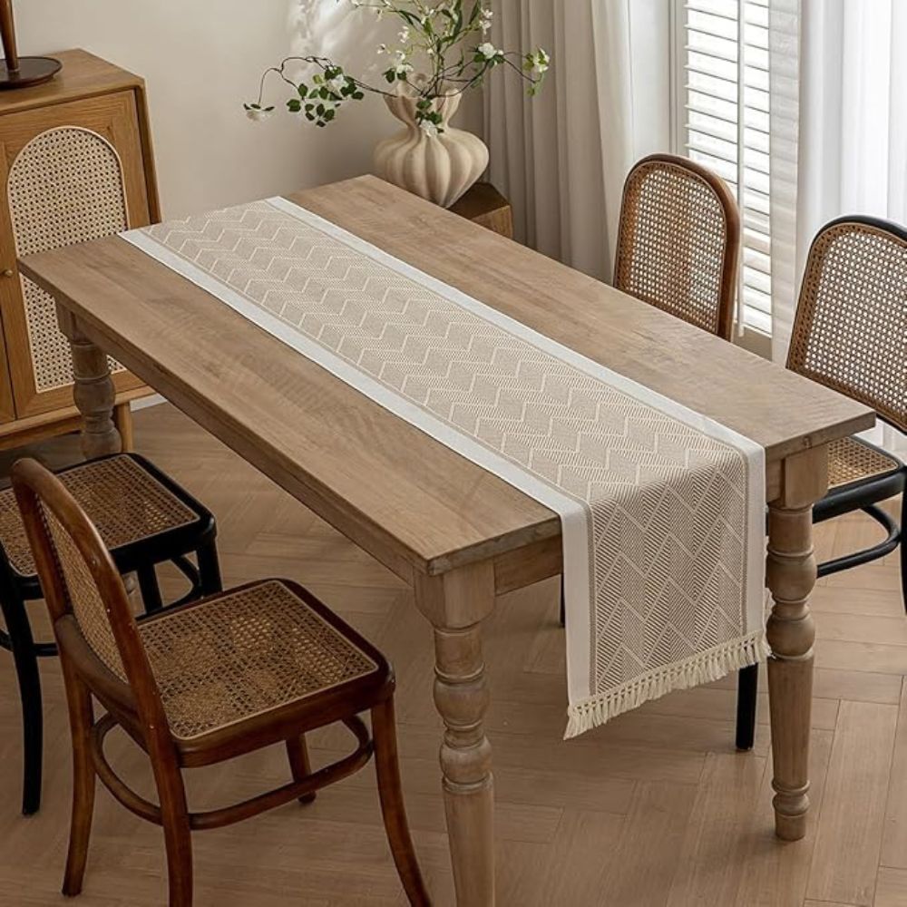 Beige table runner centered on an uncluttered wood dining table.