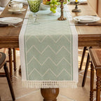 Green table runner running between place settings on a wood table.