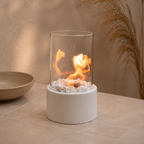 white tabletop fireplace burning on a neutral stone table