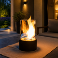 black tabletop fireplace burning on a covered patio at dusk