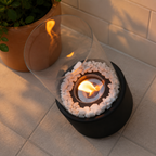 black tabletop fireplace top view showing circular burner and stones
