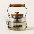 Smooth smoky glass teapot with arched wooden carry handle