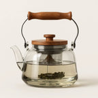 Smooth smoky glass teapot with arched wooden carry handle