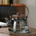 Smooth smoky glass teapot with arched wooden carry handle