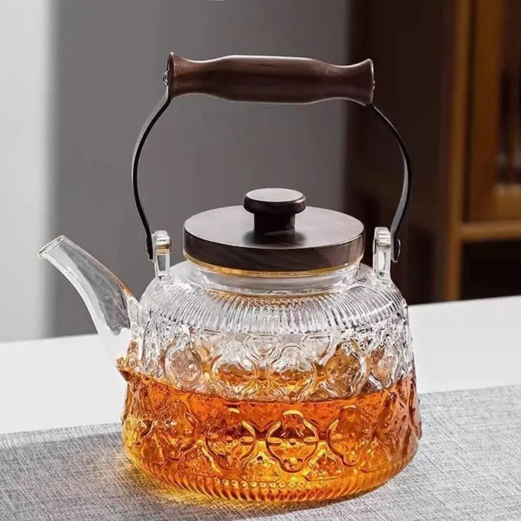 Transparent patterned glass teapot with wooden carry grip