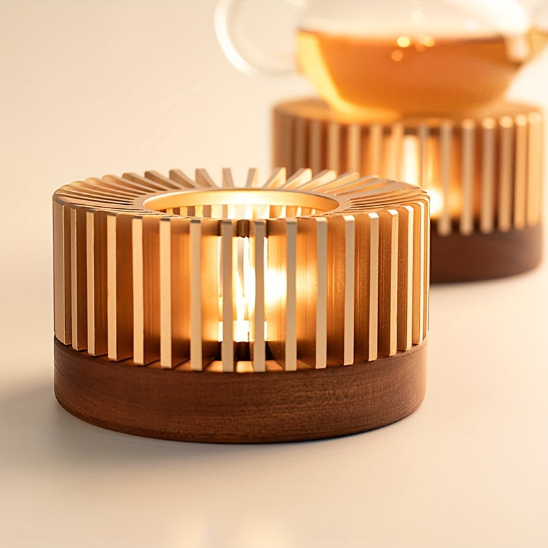 Gold tone teapot warmer with a glass teapot pictured behind it.