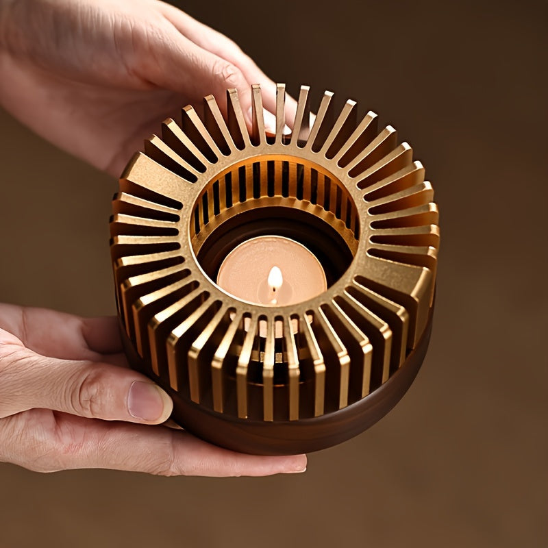 Hands holding a gold tone teapot warmer with a lit tealight inside.