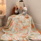 Boho floral throw blanket covering a seated reader in a cozy corner chair