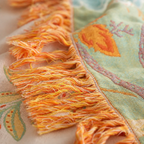 Boho floral throw blanket close up showing soft orange tassel fringe