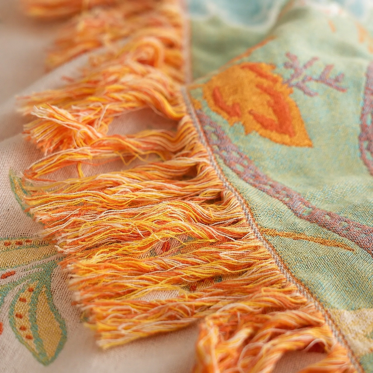 Boho floral throw blanket close up showing soft orange tassel fringe