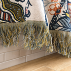 Artistic floral throw blanket close up showing multicolor tassel fringe