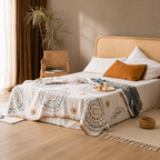 cream mandala throw blanket spread over a low bed in warm daylight