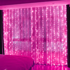 Fairy curtain lights glow bright pink behind a bed.