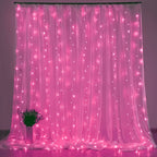 Fairy curtain lights glow pink behind a small flower arrangement.