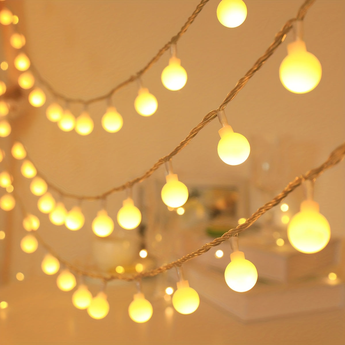 Globe fairy lights hang in warm white strands against a softly lit wall.