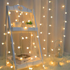 Globe fairy lights decorate a leaning mirror and white curtain.