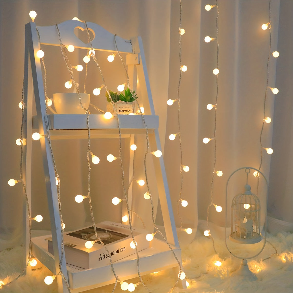 Globe fairy lights decorate a leaning mirror and white curtain.